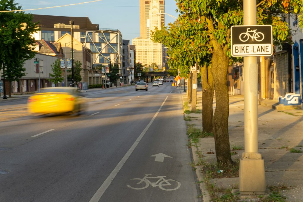 A city street with a painted bike lane and a clock tower in the background.