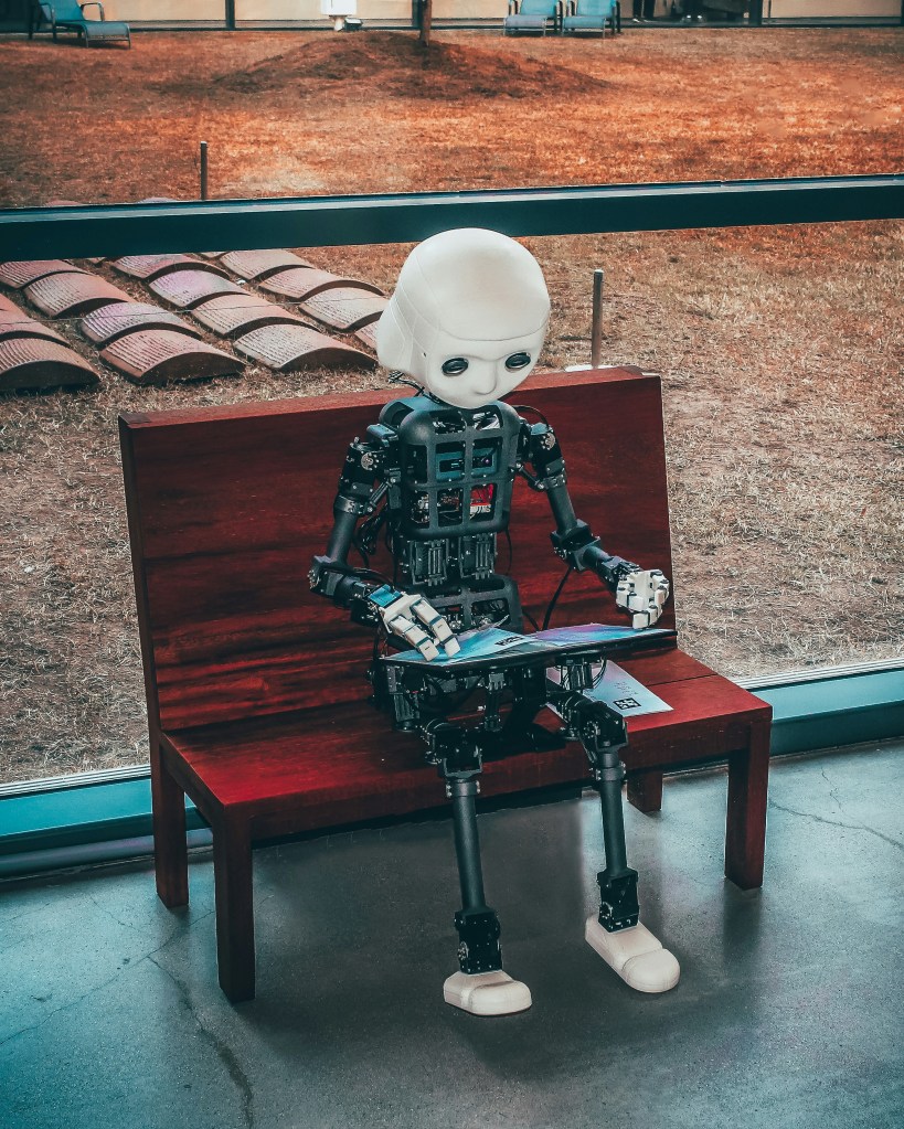 A black and white robot toy on a red wooden table